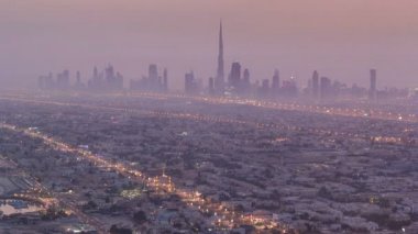 Dubai, Bae'deki Şeyh Zayed Yolu'nun Burç Halife'yi ve gökdelenlerini gösteren geceden gündüze Dubai'nin siluet görünümü. Burç Halife, 829.8m ile dünyanın en yüksek gökdeleni