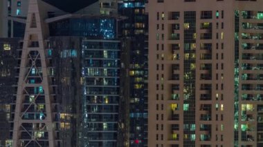 Dışarıdaki renkli binaların gece görüşü zaman ayarlı. Birçok penceresinde parlayan ışıklar olan yüksek gökdelen