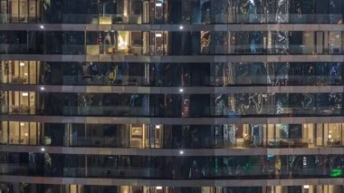 Gece vakti üst sınıf bir binanın pencerelerinin önünde oturuyorlardı. Gökdelende parlayan sarı ışıklar