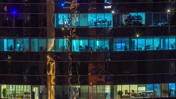 夜にはガラス張りの超高層ビルのオフィスの窓が街の灯を反射する空中時間経過とともに輝きます 夜のライトアップされた塔 — ストック動画