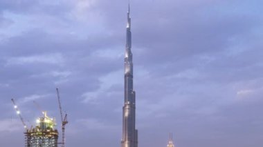 Dubai Şehir Merkezi 'nden geceye geçiş zamanı. Geceleri büyük, fütüristik şehir üzerinde hava manzarası. Dubai 'nin gökdelenleri, Birleşik Arap Emirlikleri. Akşam gökyüzü çatıdan yükseliyor