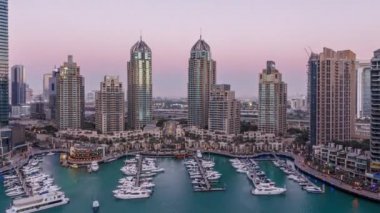 Dubai Marina gökdelenleri gün be gece geçiş zamanı panorama, lüks yatları ve marina gezinti alanı olan liman, Dubai, Birleşik Arap Emirlikleri. Aydınlatılmış kuleler ve yol trafiği