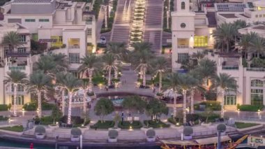Dubai Yat Limanı çeşme aeral gün gece geçiş timelapse, bağlantı noktası ile lüks yatlar ve Yat Limanı promenade, Dubai, Birleşik Arap Emirlikleri. Işıklı avuç içi ve yolda trafik