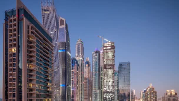 现代摩天大楼的鸟瞰天到夜转折 Timelapse 在日出之前在迪拜船坞与游艇在阿联酋迪拜 照亮的塔在晚上 — 图库视频影像