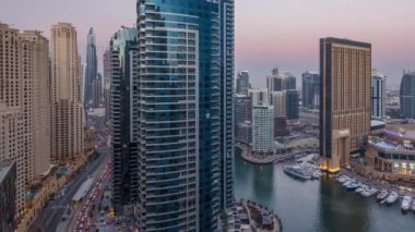 Aydınlatma için gece geçiş hava timelapse, Birleşik Arap Emirlikleri Dubai Yat Limanı günün akşam. Modern gökdelenler ve binalar. Yat ve tekne shoping mall yapay canal City yakınındaki