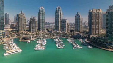 Dubai Yat Limanı gökdelenler aeral tüm gün timelapse günbatımı kadar bağlantı noktası ile lüks yatlar ve Yat Limanı sırasında gezi, Dubai, Birleşik Arap Emirlikleri. Gölge çok hızlı hareket ediyor. Mavi gökyüzü ve Zümrüt su