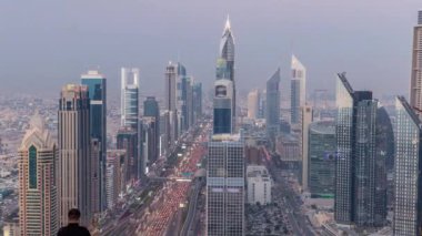 Dubai şehir manzarası gün gece geçiş timelapse için. Çok sayıda ışıklı Kuleli Şeyh Zayed Yolu üzerinde trafik çatı görünümü.