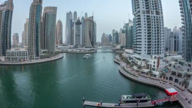 Hava üst görüntüsü, günden geceye geçiş zamanı. Dubai Marina gezinti güvertesi ve kanalı, gün batımından sonra Dubai, BAE 'de yüzen yatlar ve teknelerle dolu. Modern kuleler ve trafik