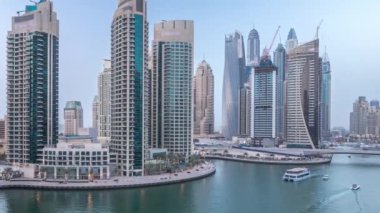 Dubai Marina gezinti güvertesi ve kanalı, gün batımından sonra Dubai, BAE 'de yüzen yat ve teknelerle hava görüntüsü. Modern kuleler ve trafik