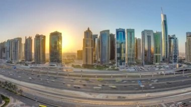 Jumeirah göl kulelerinin gökdelenleri gün doğumunda Şeyh zayed yolunda ve metro hattında trafik varken. Dubai marinasından çatı manzarası