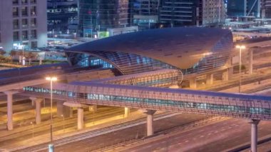 Jumeirah göl kulelerinin hava görüntüsü. Gece gündüz yaya köprüsü geçiş zamanı. Şeyh zayed yolunda ve metro hattında trafik var. Dubai marinasından güneş doğmadan önce çatı manzarası