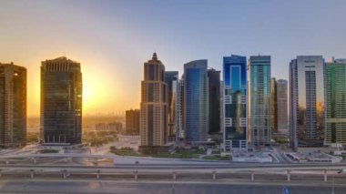Jumeirah göl kulelerinin hava görüntüsü gün doğumunda gökdelenler Şeyh zayed yolunda ve metro hattında trafik var. Dubai marinasından çatı panoramik manzarası