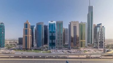 Jumeirah göl kulelerinin hava panoramik görüntüsü. Tüm gün gökdelenler. Şeyh zayed yolu ve metro hattında trafik vardı. Gölgeler çok hızlı hareket eder ve cama yansıtır.