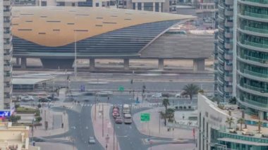 Dubai, BAE 'de gün batımından sonra metro istasyonu yakınlarındaki Dubai Marina yol kavşağının hava görüntüsü gece gündüz geçiş zamanı. Modern kuleler ve trafik