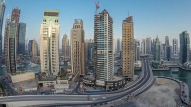 Dubai Marina gezinti güvertesi ve kanalı, gün batımından sonra Dubai, BAE 'de yüzen yat ve teknelerle hava panoramik görüntüsü. Modern kuleler ve trafik