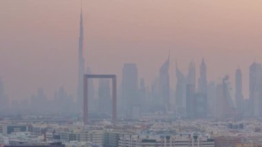 Dubai deresi manzarası günden geceye geçiş zamanı aydınlatılmış modern binalar ve şehir merkezindeki gökdelenler ve gökdelenler. Yukarıdan hava üstü görünümü