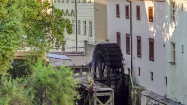 Prag 'ın merkezinde eski bir su değirmeni olan bir caddenin güzel zaman çizelgesi. Gün doğumundan sonra gölgeler evlere doğru ilerlerken.