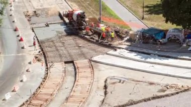 Tramvay rayları onarımı ve bakım havası olan bir yol inşaatı. Turuncu karıştırıcı kavşağın ortasına beton döküyor. Yeni toplu taşıma için demiryolu raylarının değiştirilmesi