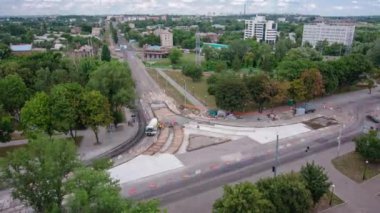 Tramvay rayları onarılan ve panoramik panoramik zaman ayarlı yol inşaatı. Beton, kavşağın ortasında mikserle çalışıyor. Taze betonu kaplıyor.