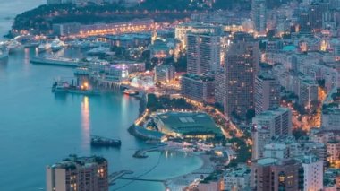 Monako 'nun büyük Corniche yolundan gece geçiş zamanına, Monako Fransa' ya giden hava manzarası. Akşam aydınlatması. Limanın suyundaki yansımalar