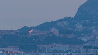 Monte Carlo 'nun şehir manzarası şatodan geceye geçiş zamanı, yaz günbatımından sonra Monako. Akşam sisi. Limandaki yatlar. Kaptan Martin 'den üst görünüm