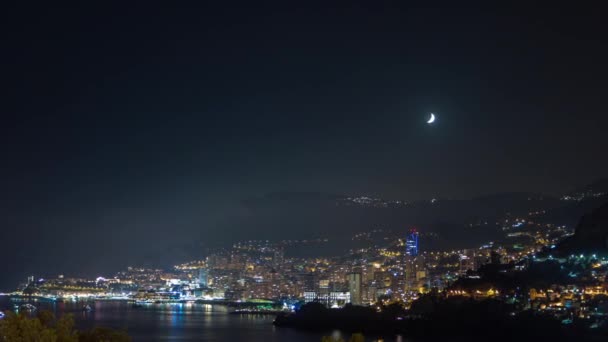 蒙特卡洛的城市景观在夜间经过 摩纳哥 月亮落日薄雾变成了云彩 建筑物的夜间照明 游艇在港口 马丁船长的头像 — 图库视频影像