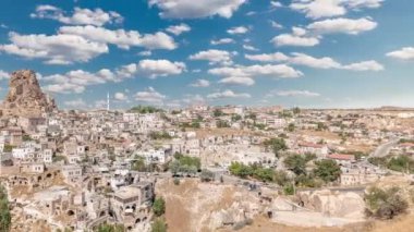 Ortahisar kasabasının eski evleri Ortahisar Şatosu 'nun zaman ayarlı kaya oluşumları. Kapadokya. Nevsehir Eyaleti. Hindi. Bulutlu mavi gökyüzü
