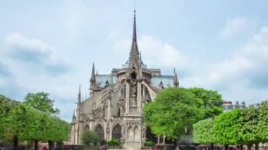 Notre Dame de Paris zaman ayarlı hiperhızlandırılmış arka plan manzaralı bahçe, Fransa. Parktaki yeşil ağaçlı anıt.