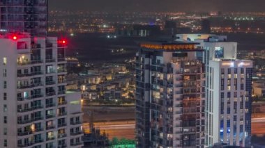 Business Bay, Dubai, Birleşik Arap Emirlikleri 'nde gece boyunca kuleleri antenli lüks evler ve villalar. Yol ve şehrin ışıklarıyla dolu göl.