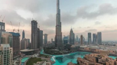 Dubai semalarında gökdelenler gün be gece yükseliyor geçiş zamanları, alışveriş merkezleri ve çeşmeler modern binalarla çevrili havadan panoramik manzara bulutlu gökyüzü
