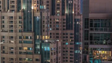Gecenin ilerleyen saatlerinde gökdelenlerin dış tarafındaki pencerelerde ışık ve zaman ayarında yanıp sönen iç ışıklar. Kulelerin havadan üst görünümü