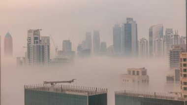 Dubai gökdelenleri, güneş doğarken iş sahasında sisle kaplıydı. Birleşik Arap Emirlikleri 'nin şehir merkezinden hava görüntüsü.