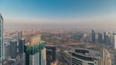 Dubai Marina Panorama 'sı JLT gökdelenleri ve golf sahası zaman çizelgesiyle gün batımında, Dubai, Birleşik Arap Emirlikleri. Yukarıdaki kulelerden hava görüntüsü. Çatıları olan şehir silüeti