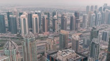 Şeyh Zayed Yolu yakınlarındaki JLT ve Dubai marina gökdelenleri. Gün gece hava geçiş zamanı. Aydınlatılmış konut binaları ve karayolu trafiği