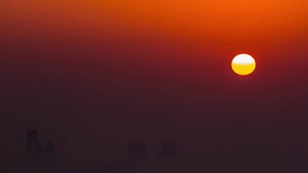朝のドバイのスカイラインを見下ろす日の出 ドバイのマリーナからの空中トップビューのタイムラプス 高層ビルの周りをオレンジ色の空の大きな太陽が霧の上に昇る アラブ首長国連邦 — ストック動画
