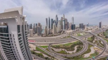 Dubai Marina karayolu kavşağındaki panorama spagetti kavşağı zaman dilimi. Arka plandaki en uzun gökdelenler. JLT bölgesinden hava görüntüsü. Bulutlu gökyüzü