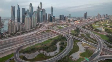 Dubai Marina karayolu kavşağındaki panorama spagetti kavşağı günden geceye geçiş zamanı. Gün batımından sonra en uzun gökdelenler ve arka planda golf sopası. JLT 'den hava üst görünümü