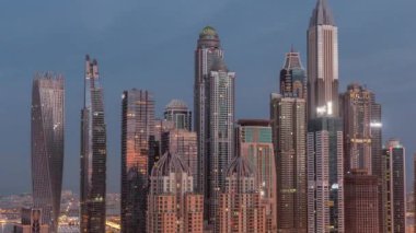 Dubai Marina 'nın gökdelenleri gece gündüz geçiş zamanlarında en yüksek konut binalarıyla aydınlandı. Güneş doğmadan önce JLT bölgesinden hava üst görünümü