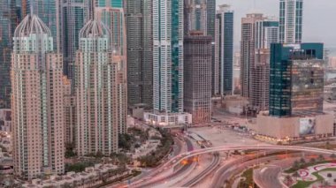Dubai Marina 'nın gökdelenleri gün batımından gece saatlerine kadar aydınlatılmış en yüksek konut binaları. Otoyol kavşağı olan JLT bölgesinin hava üst görüntüsü