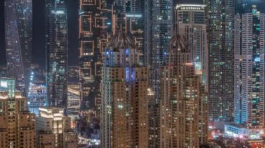Dubai Marina 'nın gökdelenleri tüm gece boyunca en yüksek konut binalarında yanıp sönen pencereler. JLT bölgesinden hava üst görünümü