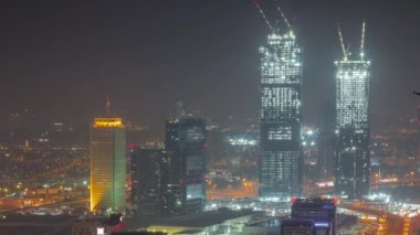 Tüm gece boyunca Dubai 'deki Dünya Ticaret Merkezi ile aydınlık gökdelenlerin hava manzarası. Işıklar kapalıyken. Yeni ikiz kulelerin inşaatı. Bur Dubai ve Deira bölgesi