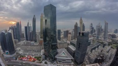 Sheikh Zayed karayolu zaman çizelgesinde Dubai 'deki finans merkezinde gün batımına sahip gelecekçi gökdelenlerin manzarası. Yukarıdan gökyüzü turuncu bulutlu