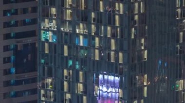 Gecenin ilerleyen saatlerinde gökdelenlerin dış tarafındaki pencereler zaman ayarında parıldıyor ve yanıp sönüyor. Havadan üst görünüm