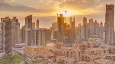 Dubais iş hangarı kuleleri, gün batımında hava saatinde. Bazı gökdelenlerin çatı manzarası ve inşaat halindeki yeni kuleler. Turuncu gökyüzü Eski kasaba bölgesi üzerinde ışık huzmeleriyle