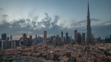 Dubai şehir merkezi panorama gece gündüz geçiş zamanı en yüksek gökdelen ve diğer kule manzaralı Dubai, Birleşik Arap Emirlikleri gün batımından sonra tepeden. Işıklar yanıyor..