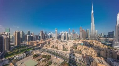 Dubai Şehir Merkezi 'nin sabah saatlerinde güneş en yüksek gökdelenden ve gündoğumu sırasında tepeden uzun gölgeli diğer kulelerden yansıyan Birleşik Arap Emirlikleri. Eski şehrin geleneksel evleri