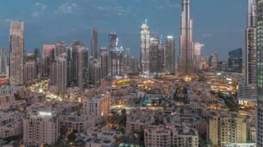 Dubai Şehir Merkezi 'nden gece gündüz geçiş zamanı en yüksek gökdelen ve diğer aydınlatma kuleleri ile güneş doğmadan önce pembe bulutlu Birleşik Arap Emirlikleri. Geleneksel evler