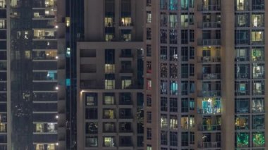 Modern konut binalarındaki büyük parlayan pencereler gece saatlerinde, sıra sıra parlıyor..