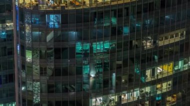 Modern ofisteki büyük parlayan pencereler ve konut binaları gece saatlerine göre ayarlanıyor, pencereler ışık saçıyor. Finans bölgesinde gökdelenler