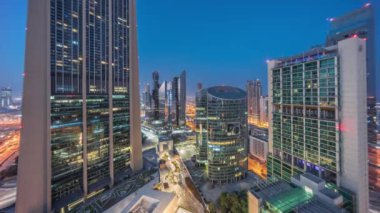 Dubai Uluslararası Finans Merkezi gökdelenleri gece gündüz geçiş panoramik zaman dilimi. Aydınlatılmış kuleler güneş doğmadan önce yukarıdan görünür